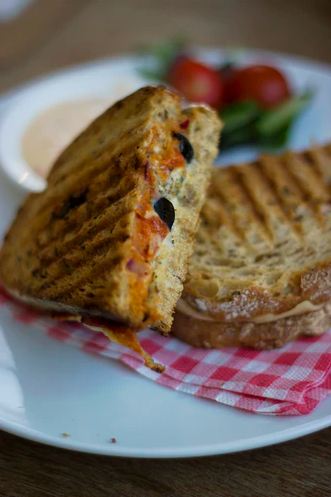 A grilled cheese sandwich with olives.