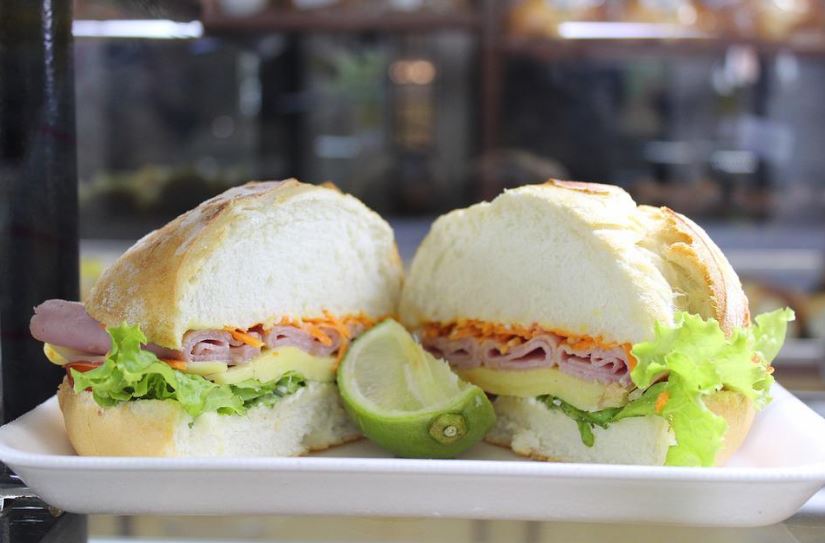 a turkey sandwich cut in half with a sliced lime at the center