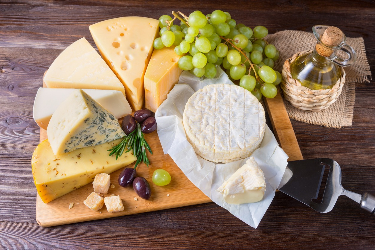 a variety of cheese on a cheese plate