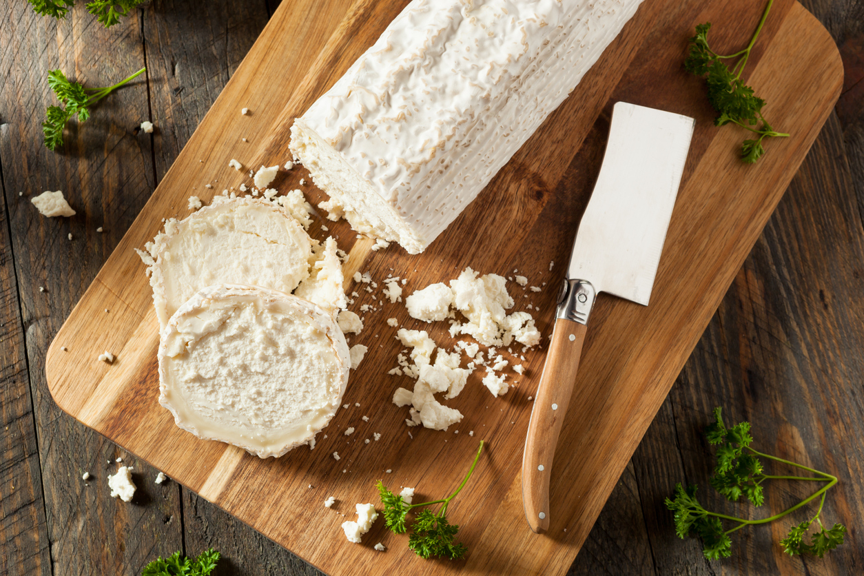 raw, white organic goat cheese on a chopping board
