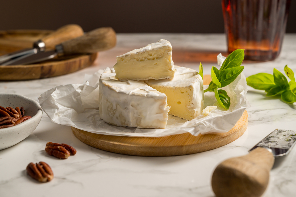Cheese board, different types of cheese on a board, served with grapes and dried fruits