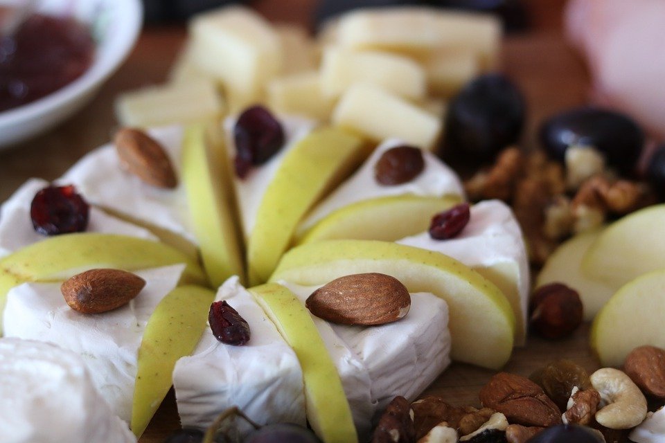 a cheese platter with fruits and nuts