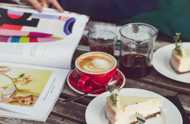 Cheese Cake, coffee and magazine on table