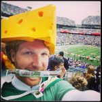 man wearing a cheesehead hat in a stadium