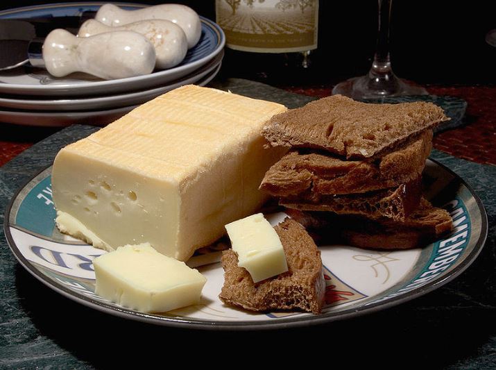 Limburger cheese on a plate next to pieces of bread