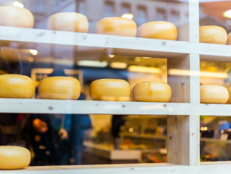 cheese wheels on the shelves of a cheese store