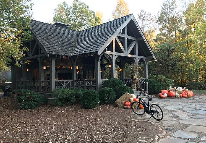 the Blackberry Farmhouse with a bike, pumpkins, shrubs, and trees