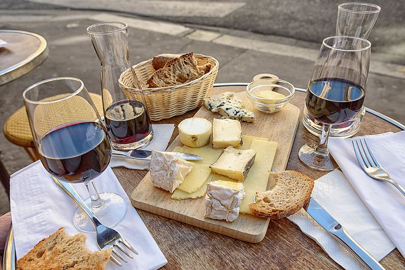 various cheeses on a cheeseboard served with wine